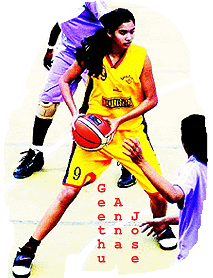 Action shot of Geethu Anna Jose, in yellow Indian Railways uniform number 9, in action, with basketball.