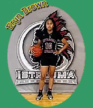 Image of Louisiana girls basketball player, #10 on Istrouma High School, shown, ball on right hip, left hand on left hip, posing in fron of the image of the mascot Indian Brave.
