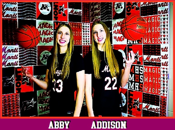The Ruda Twins, Abby (#33), on the left, & Addison (#22), back to back, throwing basketballs in the air for the Monticello High team in Minnesota in their white scripted Magic jerseys.