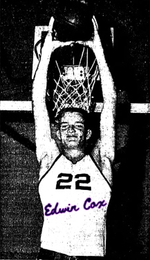 Boys basketball player, Edwin Cox, in Brookesmith High School (Texas) uniform #22, with ball held high overhead, facing camera, with ball above basket. From the Brownwood Bulletin, Brownwood, Texas, February 14, 1958.