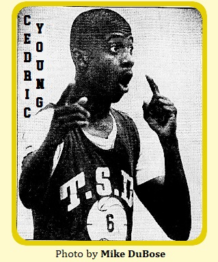 Image of Cedric Young, basketball player for the Tennessee School for the Deaf, signing his signals to our rught, in his T.S.D. uniform #6 (in a white basketball image_ during a game. From The Knoxville News-Sentinel, Knoxville, Tenn., November 25, 1985. Photograph by Mike DuBose.