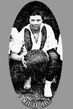 Image cropped from team photo, of Martha Carey, Sargent School in Massachusetts, crouching, holding basketball. From The Boston Daily Globe, Boston, Mass., Mar 13, 1919.