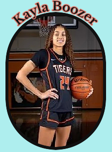 Kayla Boozer, Californian girls basketball player for South Pasadena High, posing in her black #24 uniform, red on black with TIGERS in white, holding basketball aginst her keft side at belly level.