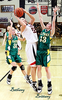 Action shot from the Kokomo Perspective of Bethany and Brittany Neeley, Eastern High School (Indiana) basketball players, guarding a player in the act of shooting.