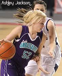 Image of Ashley Jackson, Knoxville High School (Tennessee) basketba;; player, number 52, driving with the ball past an opponent.