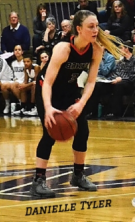 Danielle Tyler, Whatcom Community College women's basketball player (Illinois) in dark uniform holding the ball in action. 