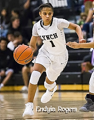 Image of girls basketball player, Endyia Rogers of Bishop Lynch High School (Texas). Dribbling the ball in her white LYNCH, #1 uniform in game she scored 50 (12/7/2018).