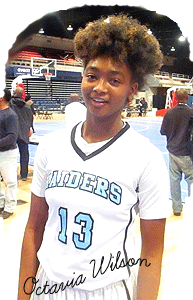 Image of Octavia Wilson, Eleanor Roosevelt High School (Maryland) basketball player, in white uniform with black outlined blue lettering reading RAIDERS and the number 13.