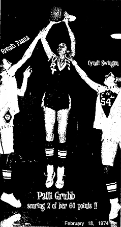 Patti Grubb, Burt Bear High School basketball player, up in the air shooting a jump shot for 2 of her 60 points scored in the Burt sectional semi-final game, February 18, 1974, a 84-71 win over Woden-Crystal Lake. One either side are opposing players trying to block the shot. From the Algona Upper Des Moines newspaper issue of February 21, 1974. Text reads: 'NO WAY to stop Burt's PAtti Grubb on this one. She was from 15 feet in, giving the Bears 60 of their 84 points Monday night. Trying to stop her are W-CL guards Cyndi Swingen (54) and Brenda Hanna.'