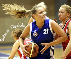 Image of Sabine Niedola, Liepajas Metalurgs basketball player driving on a RTU-Merks player, pony tail flying behind her, on the night she scored 44 points, 8 October, 2009.