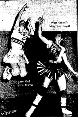 Picture of Sylvia Murray, Aurora High School (Iowa) Lady Owl 6-on-6 basketball player, high in the air with her legs folded up, trying to shoot over West Central High's Mary Ann Roquet, in a 58 to 48 loss at Maynard on November 21, 1957. Murray scored 24 points in the game, as reported in the Oelwein Daily Register on 11/22/1957. (Register Photo)